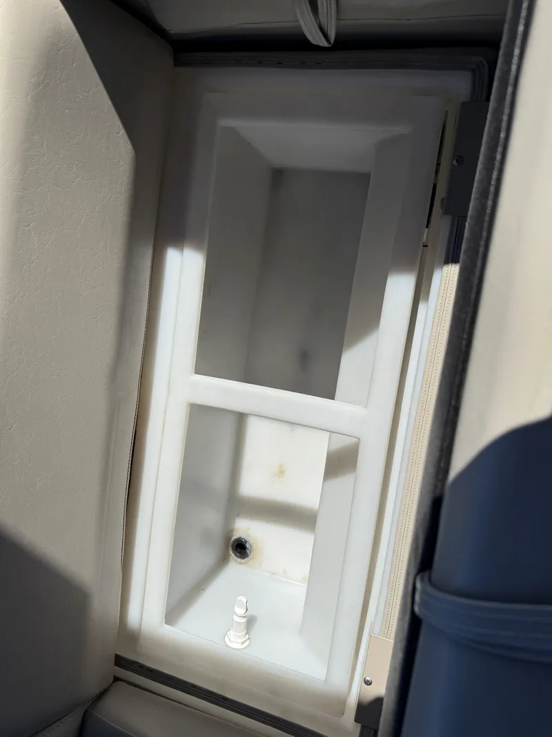 Slide: The Image of Storage compartment in a 2019 South Bay 222CR boat, featuring a white interior. - 21