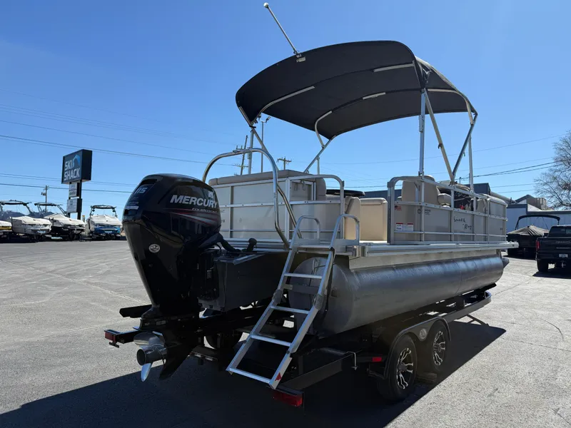 Slide: The Image of 2019 South Bay 222CR pontoon boat with Mercury outboard engine and canopy, parked on trailer. - 3