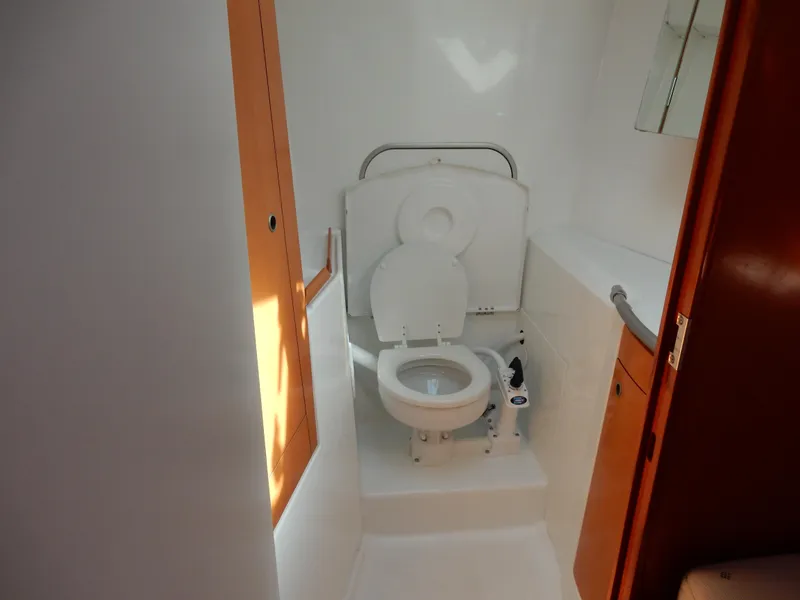 Slide: The Image of Beneteau First 44.7 2005 yacht bathroom with toilet and wooden accents. - 13