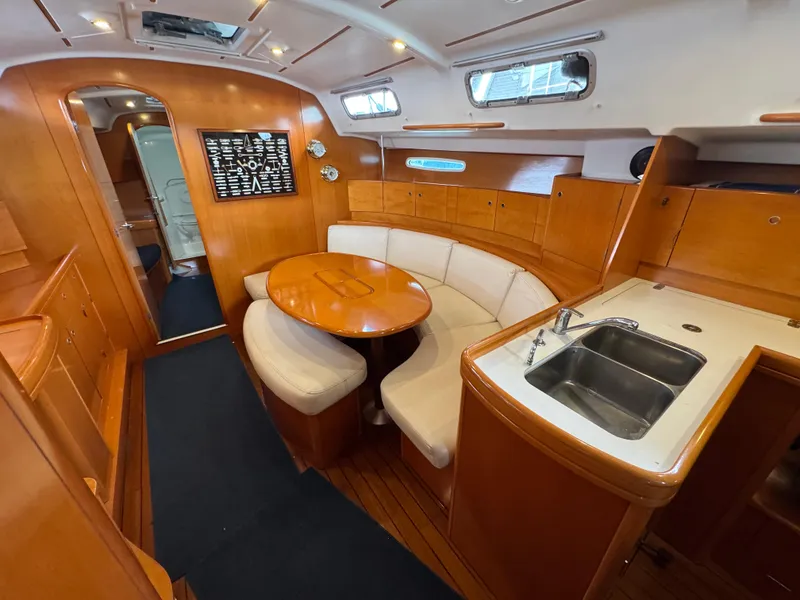 Slide: The Image of Interior of 2005 Beneteau First 44.7 yacht with wooden finish and cozy seating area. - 22