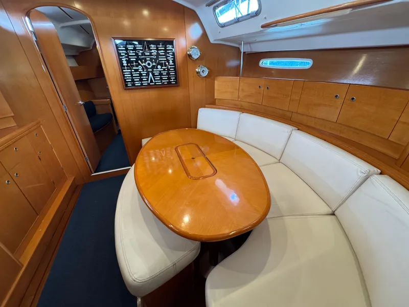 Slide: The Image of 2005 Beneteau First 44.7 yacht interior with wooden table and white seating. - 23