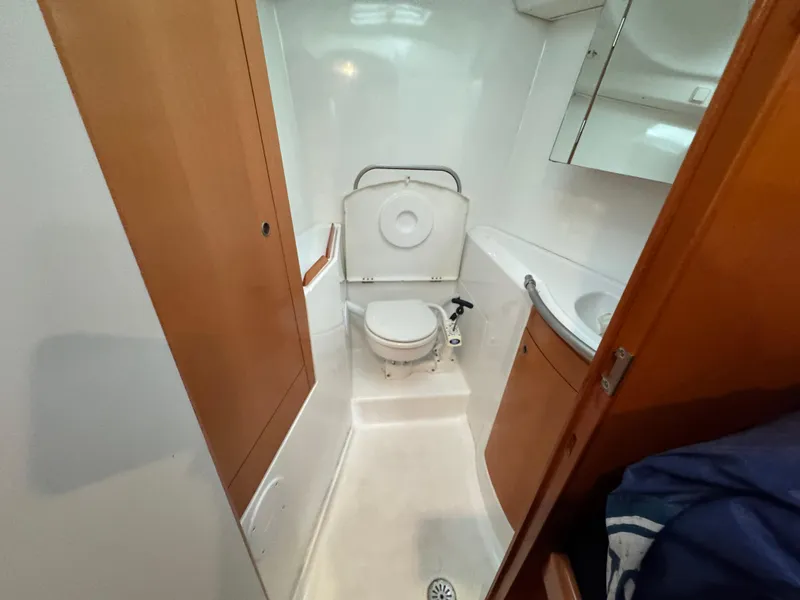 Slide: The Image of 2005 Beneteau First 44.7 yacht bathroom with toilet, sink, and wooden cabinetry. - 29