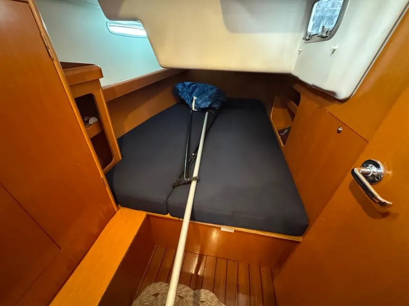Slide: The Image of Cozy cabin interior of 2005 Beneteau First 44.7 sailboat with wooden finish and blue bedding. - 32