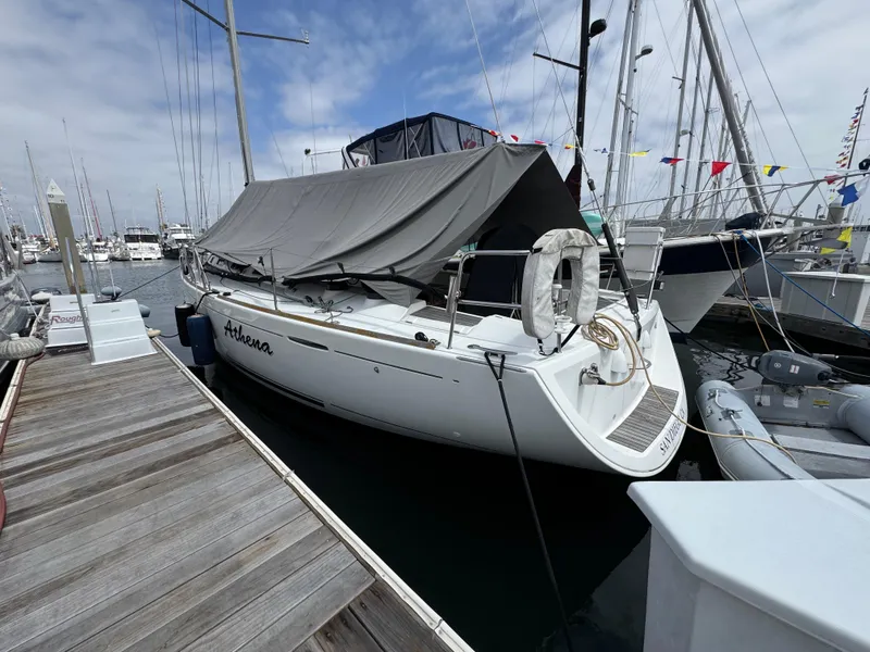 Slide: The Image of 2005 Beneteau First 44.7 sailboat docked, covered, with lifebuoy and marina background. - 36