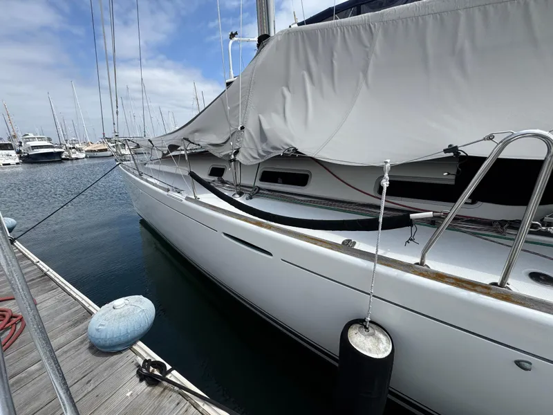 Slide: The Image of 2005 Beneteau First 44.7 sailboat docked at marina, covered deck, calm water. - 38