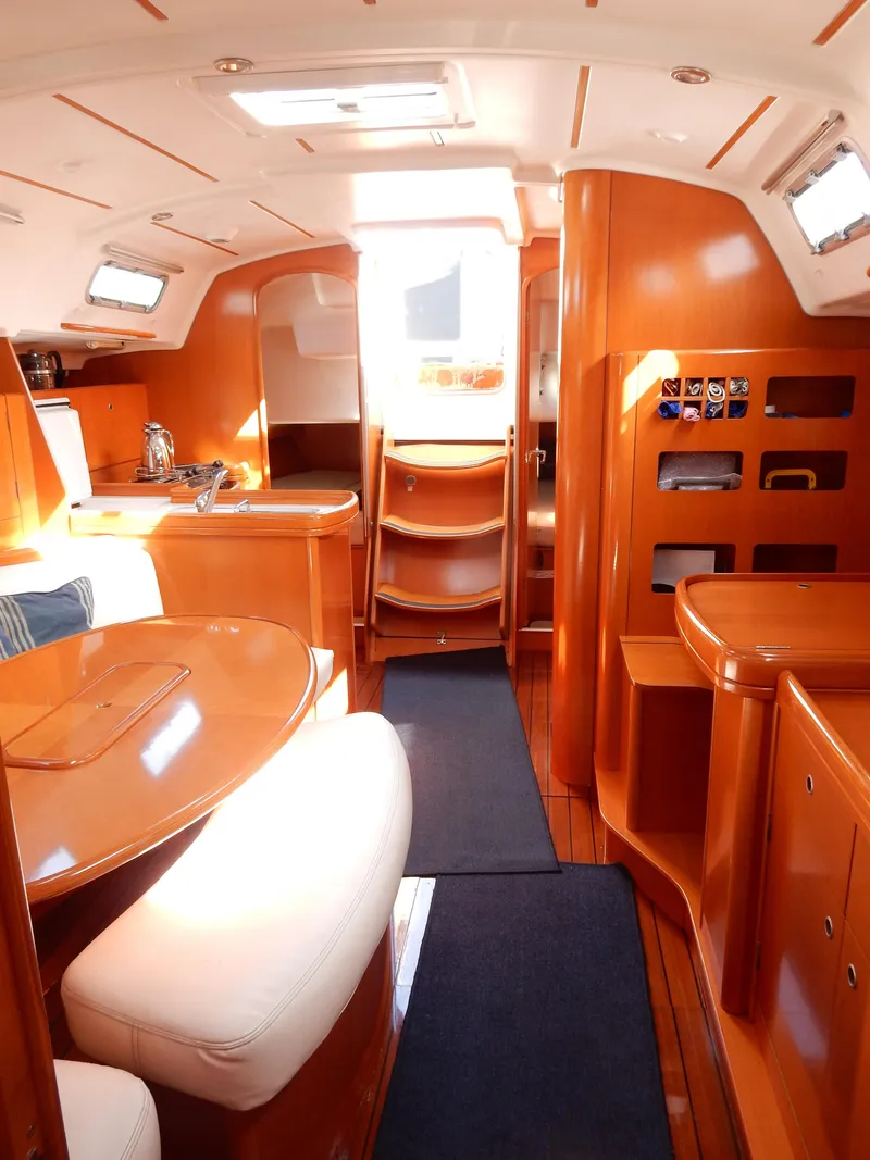 Slide: The Image of 2005 Beneteau First 44.7 yacht interior with wood finish and cozy seating area. - 5