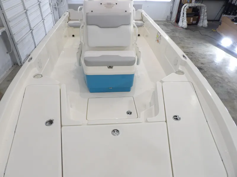 Slide: The Image of 2019 Skeeter SX210 boat interior with white and gray seating in a garage setting. - 13