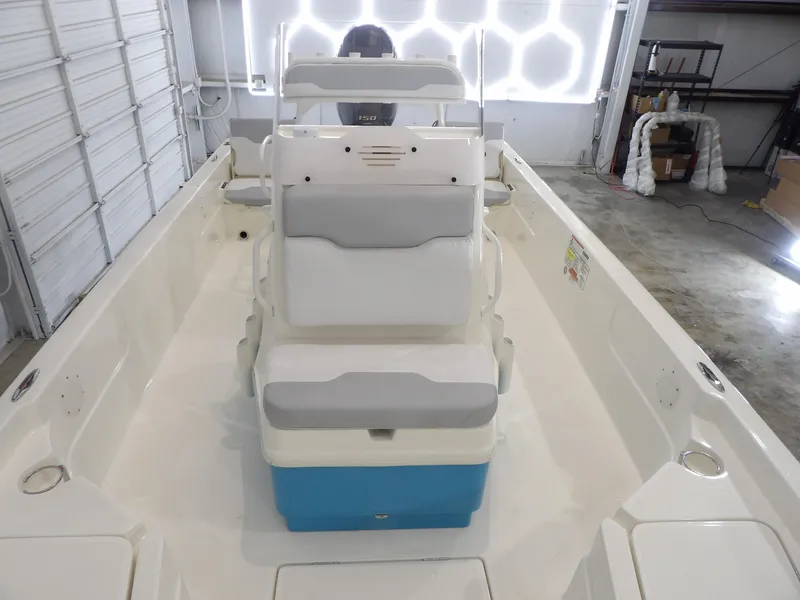 Slide: The Image of 2019 Skeeter SX210 boat interior with seating and console in a garage setting. - 14
