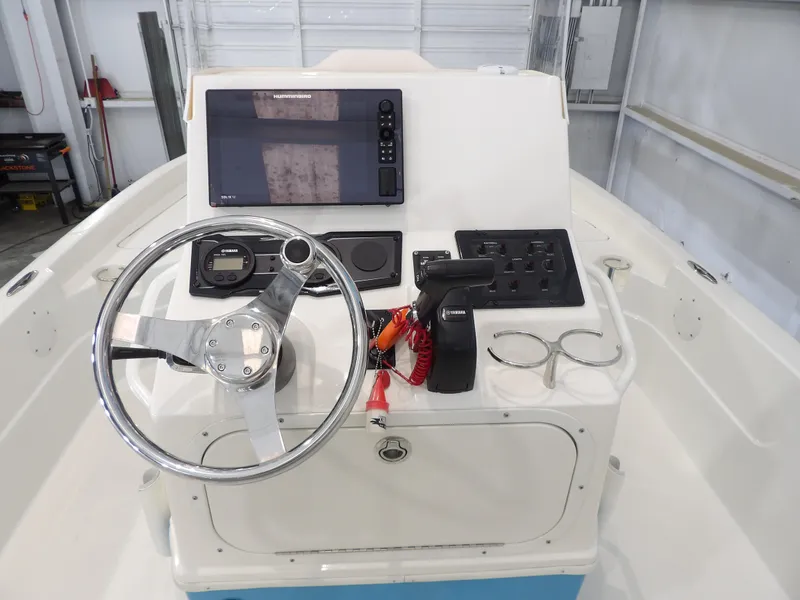 Slide: The Image of 2019 Skeeter SX210 boat console with steering wheel, controls, and navigation display. - 16