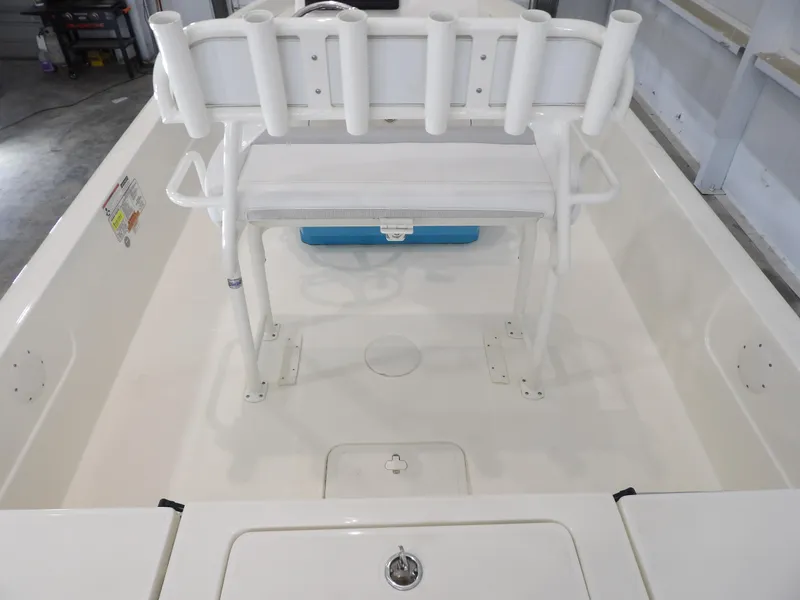 Slide: The Image of 2019 Skeeter SX210 boat interior with rod holders and seating in a garage setting. - 20