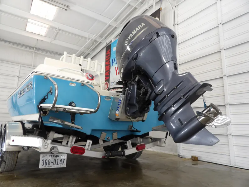 Slide: The Image of 2019 Skeeter SX210 boat with Yamaha outboard motor in a garage setting. - 7