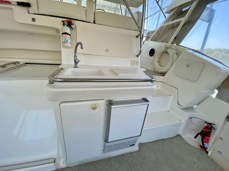 Slide: The Image of 1999 Silverton 392 Motor Yacht interior with sink, mini fridge, and fire extinguisher. - 13