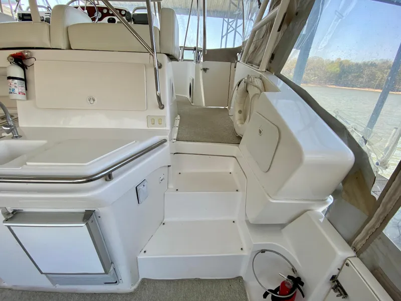 Slide: The Image of 1999 Silverton 392 Motor Yacht interior with white seating and steps, featuring a fire extinguisher. - 14