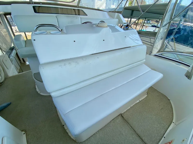 Slide: The Image of 1999 Silverton 392 Motor Yacht interior with white seating and helm station. - 16
