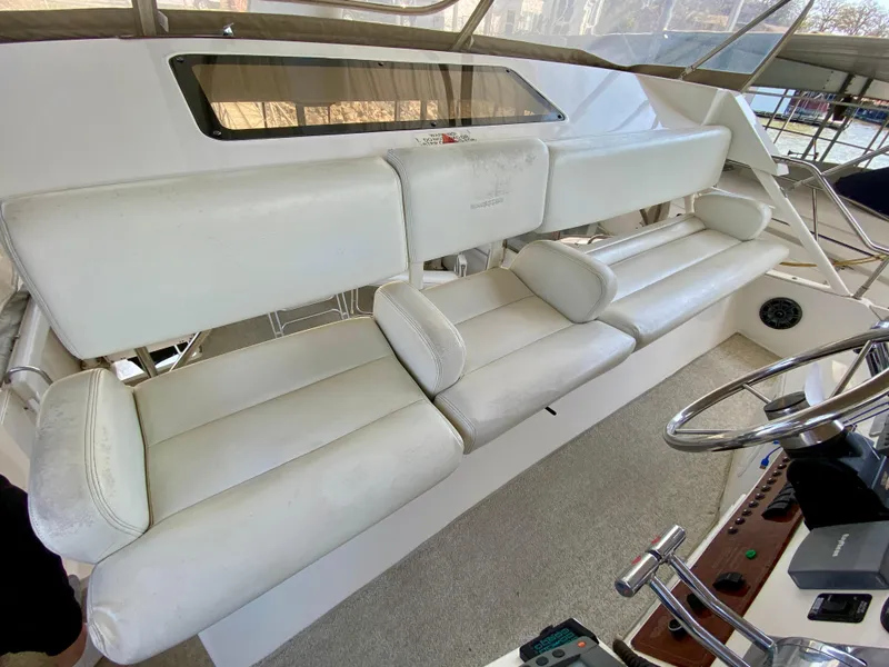 Slide: The Image of 1999 Silverton 392 Motor Yacht interior with white seating and steering wheel. - 17