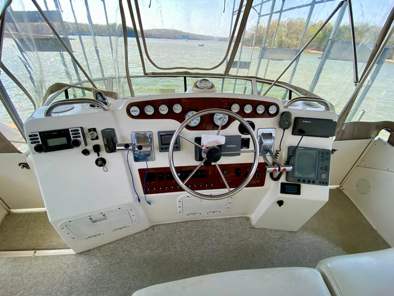 Slide: The Image of 1999 Silverton 392 Motor Yacht helm with steering wheel, gauges, and navigation equipment. - 18
