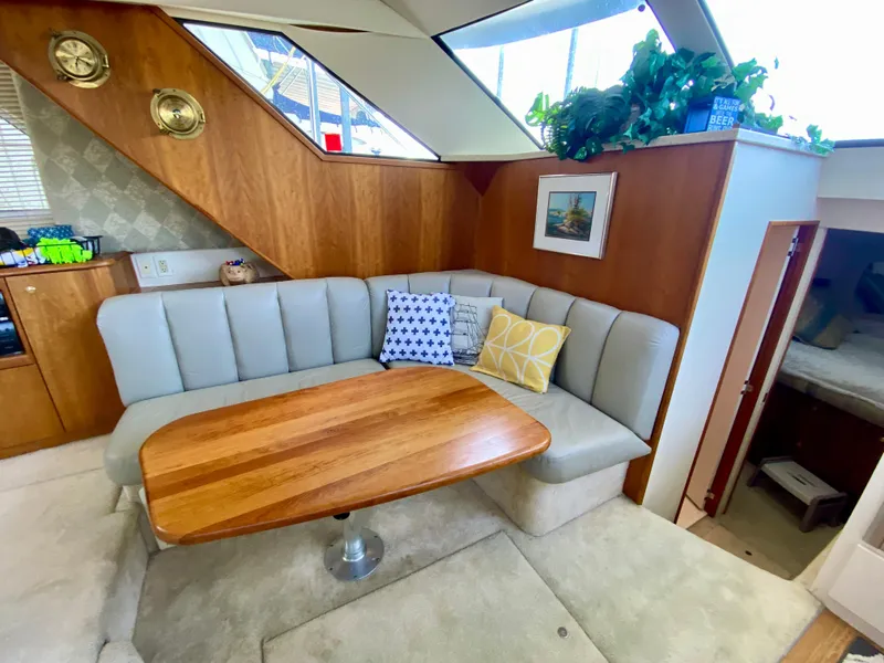 Slide: The Image of Interior of 1999 Silverton 392 Motor Yacht with cozy dining area and wooden table. - 23