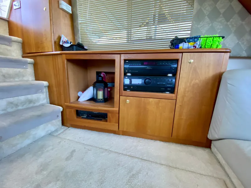 Slide: The Image of 1999 Silverton 392 Motor Yacht interior with wooden cabinetry and entertainment system. - 25