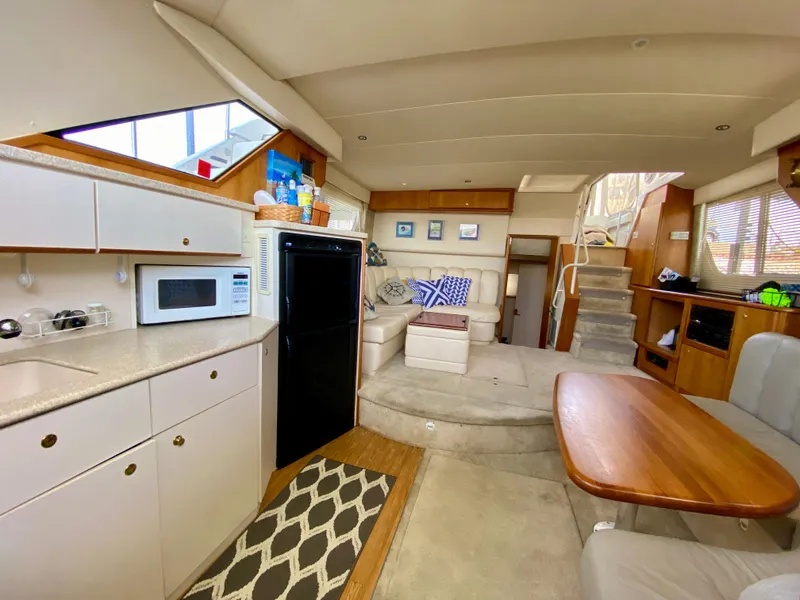 Slide: The Image of Interior of 1999 Silverton 392 Motor Yacht with kitchen and seating area. - 27