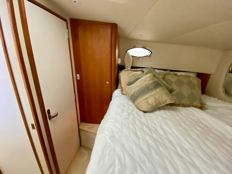 Slide: The Image of Cozy bedroom interior of 1999 Silverton 392 Motor Yacht with plush bedding and wooden accents. - 29