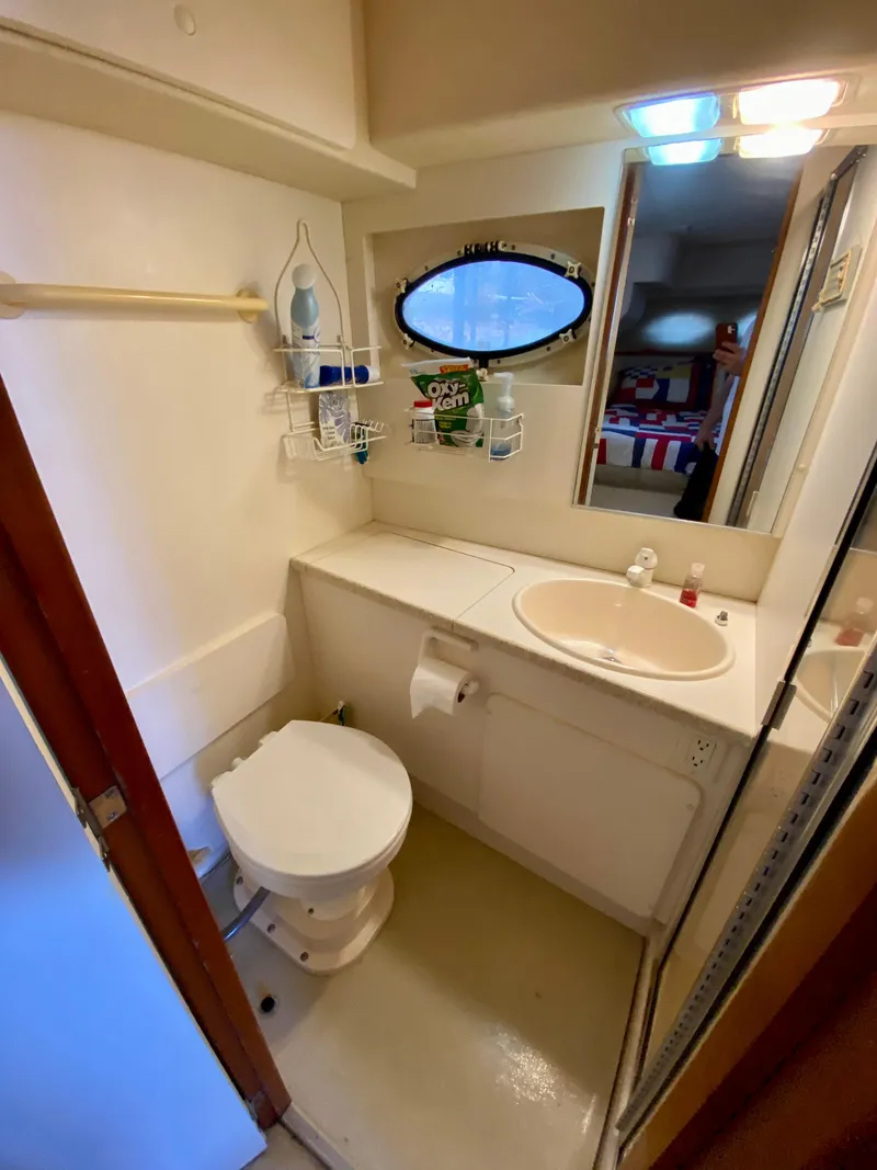 Slide: The Image of 1999 Silverton 392 Motor Yacht bathroom with sink, toilet, and storage shelves. - 34
