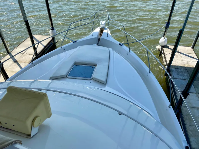 Slide: The Image of 1999 Silverton 392 Motor Yacht docked, showcasing sleek bow design and water view. - 38