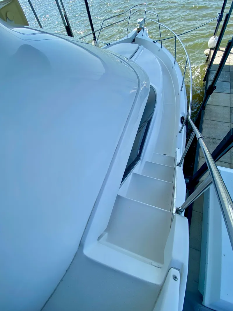 Slide: The Image of 1999 Silverton 392 Motor Yacht docked, showcasing sleek design and spacious deck. - 5