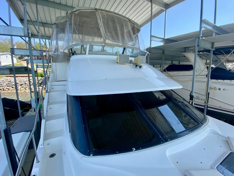 Slide: The Image of 1999 Silverton 392 Motor Yacht docked under a covered marina. - 9