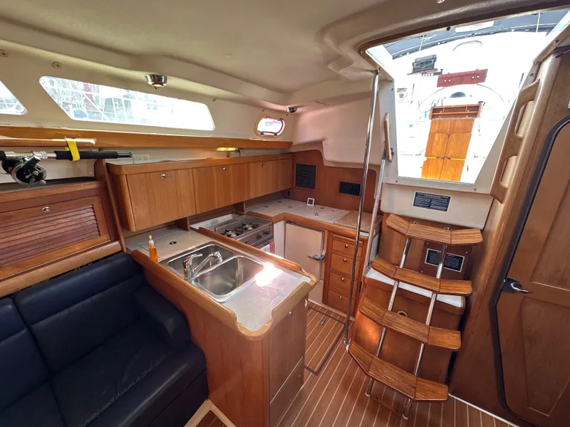 Slide: The Image of Interior of a 2005 Catalina 350 yacht with kitchen and seating area. - 49
