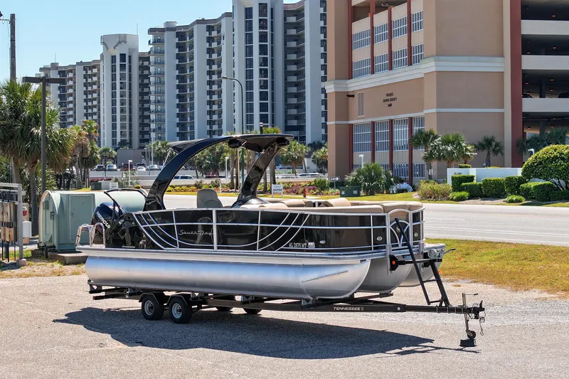 Slide: The Image of 2015 South Bay 724 SPORT DLX pontoon boat on trailer, urban background. - 23
