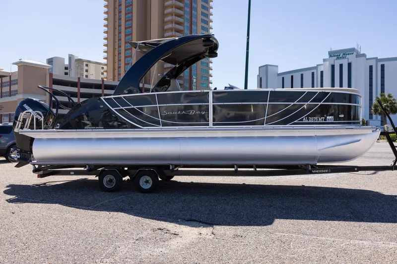 Slide: The Image of 2015 South Bay 724 SPORT DLX pontoon boat on trailer, parked near buildings. - 7