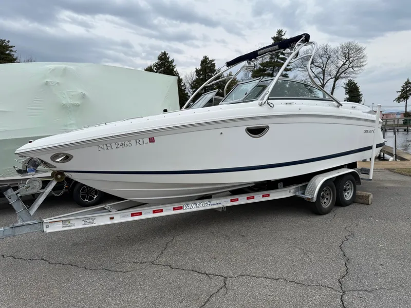 Slide: The Image of 2013 Cobalt 242 boat on a trailer, parked outdoors under cloudy skies. - 1