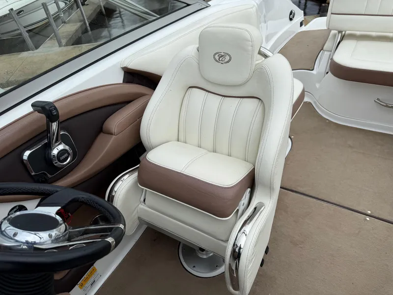 Slide: The Image of Captain's seat in a 2013 Cobalt 242 boat, featuring luxurious white and brown upholstery. - 13