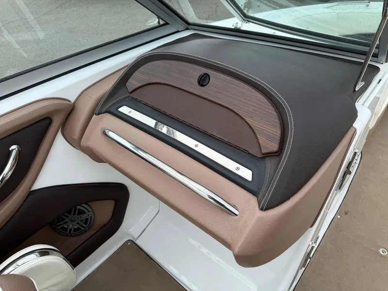 Slide: The Image of 2013 Cobalt 242 boat interior with brown dashboard and speaker detail. - 15