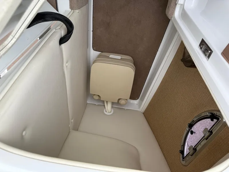 Slide: The Image of Interior cabin of a 2013 Cobalt 242 boat, featuring a compact toilet. - 21
