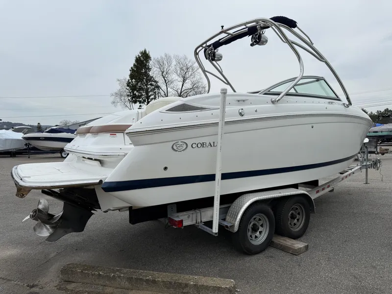 Slide: The Image of 2013 Cobalt 242 boat on trailer, white exterior, parked outdoors. - 4