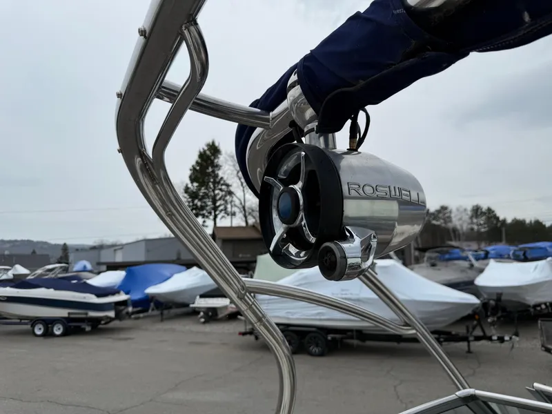 Slide: The Image of 2013 Cobalt 242 boat with Roswell speaker, surrounded by covered boats in a marina. - 8