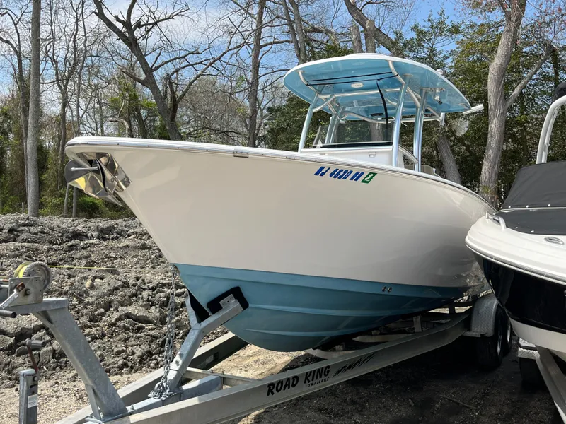 Slide: The Image of 2017 Sportsman 252 boat on trailer, parked outdoors, surrounded by trees. - 1