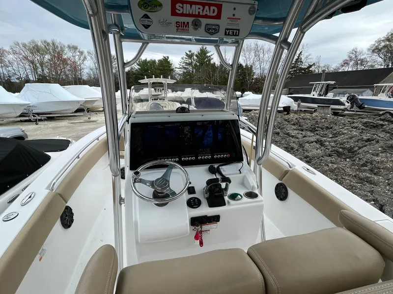 Slide: The Image of 2017 Sportsman 252 boat cockpit with steering wheel, navigation system, and beige seating. - 17