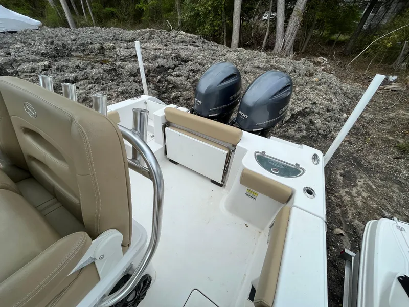 Slide: The Image of 2017 Sportsman 252 boat with dual engines and beige seating, parked on rocky terrain. - 22