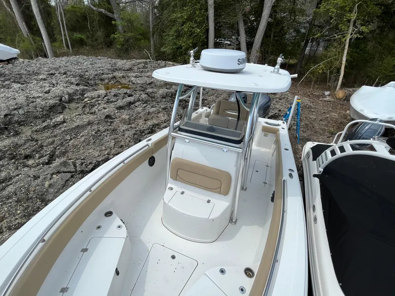 Slide: The Image of 2017 Sportsman 252 boat with T-top, docked near rocky shore and trees. - 28