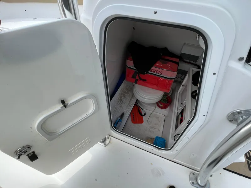 Slide: The Image of Open storage compartment on a 2017 Sportsman 252 boat, containing various items. - 31