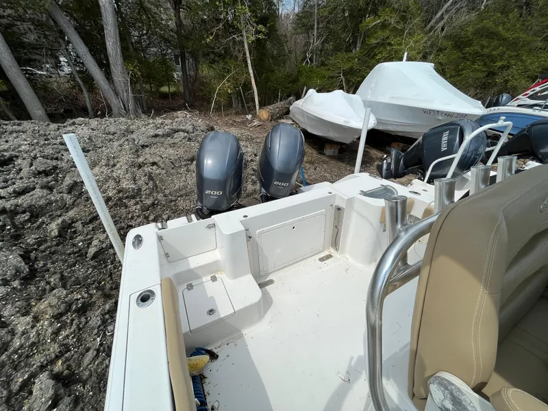 Slide: The Image of 2017 Sportsman 252 boat with dual outboard motors, parked on rocky terrain. - 6