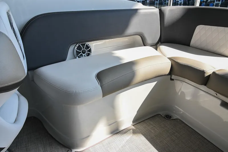 Slide: The Image of 2021 Crownline 265 SS boat interior seating with speaker, featuring gray and beige upholstery. - 15