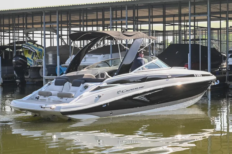 Slide: The Image of 2021 Crownline 265 SS boat docked in marina, featuring sleek design and modern amenities. - 2