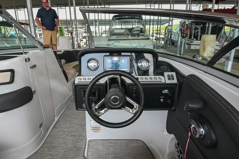 Slide: The Image of 2021 Crownline 265 SS boat dashboard with steering wheel and control panel. - 25