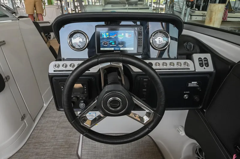 Slide: The Image of 2021 Crownline 265 SS boat dashboard with steering wheel and digital display. - 27