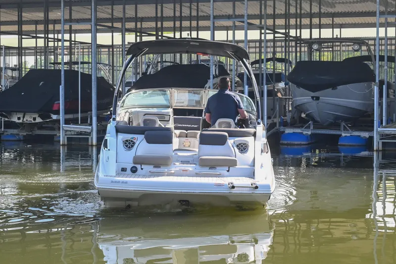 Slide: The Image of 2021 Crownline 265 SS boat docked in a marina, rear view. - 3