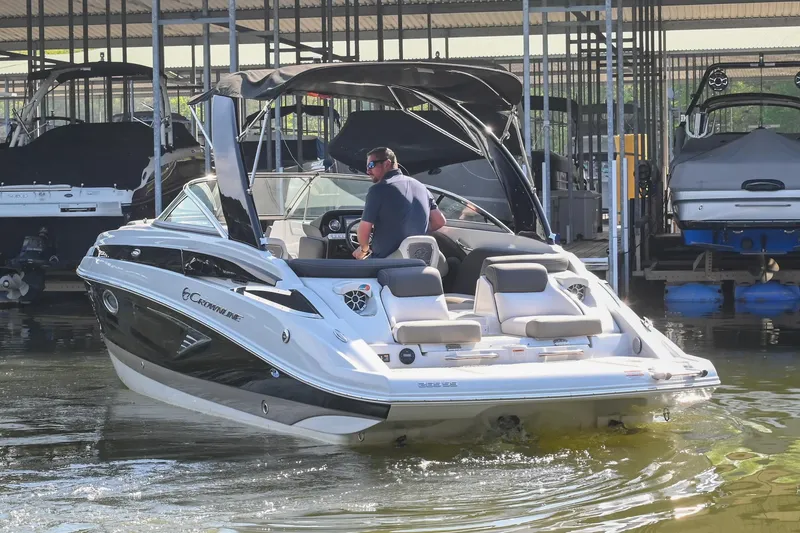 Slide: The Image of 2021 Crownline 265 SS boat docked with a person at the helm. - 4