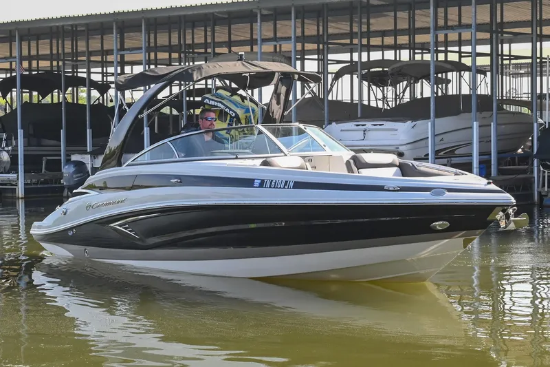 Slide: The Image of 2021 Crownline 265 SS boat docked on calm water, featuring sleek design and modern amenities. - 7
